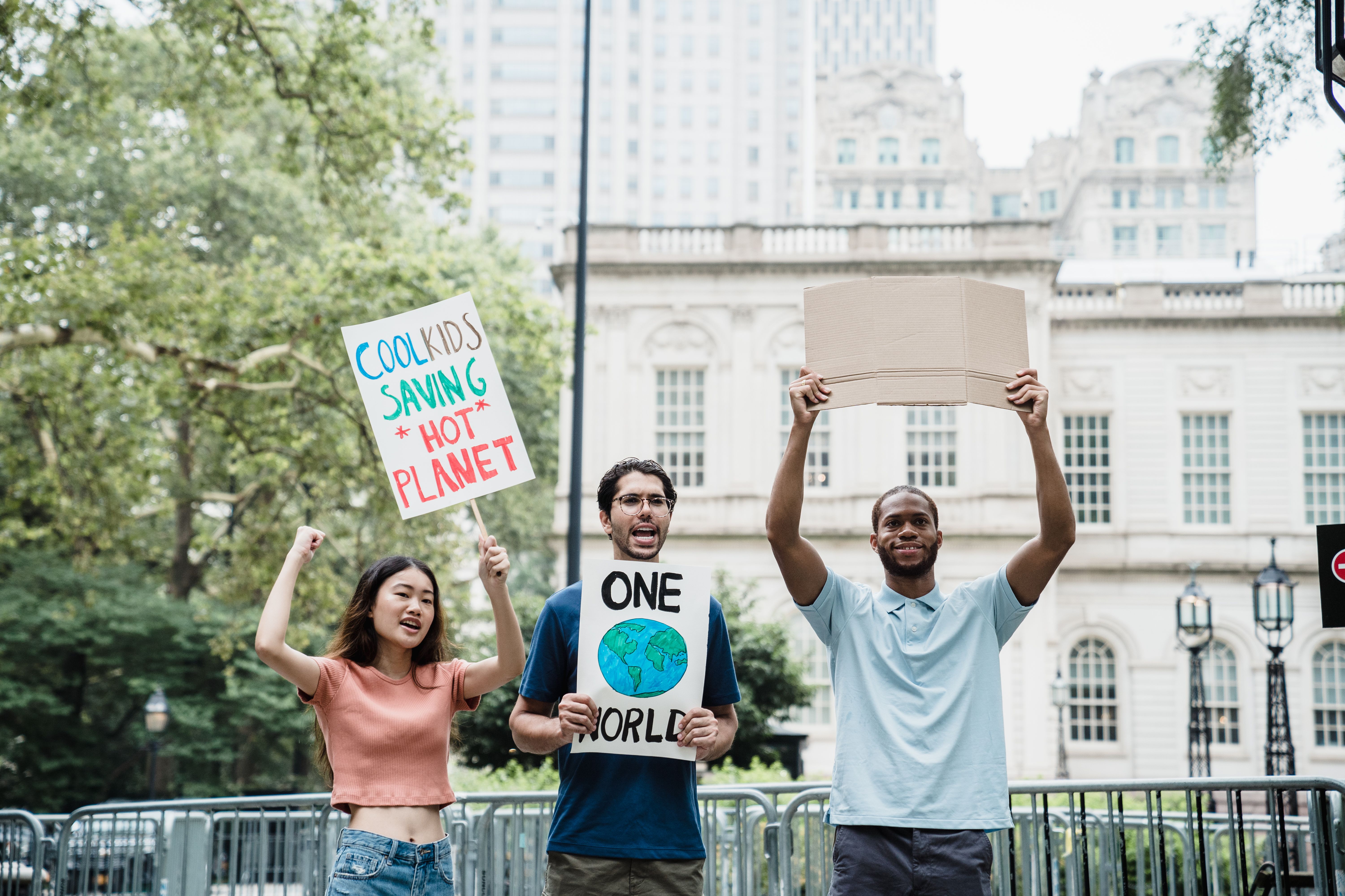 Young activists holding climate and environmental protest signs at a city rally